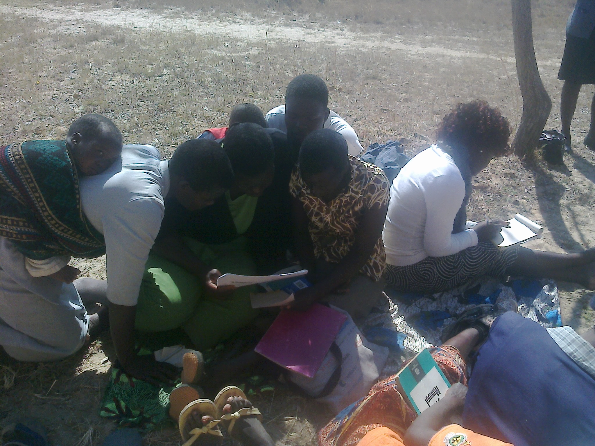 A group discussing written materials outdoors